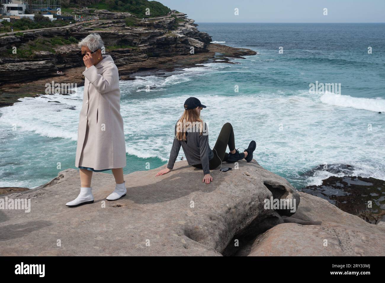 27.09.2019, Sydney, New South Wales, Australia - Young and elderly woman are seen on the cliffs at Tamarama Point along Bondi to Bronte Coastal Walk. Stock Photo