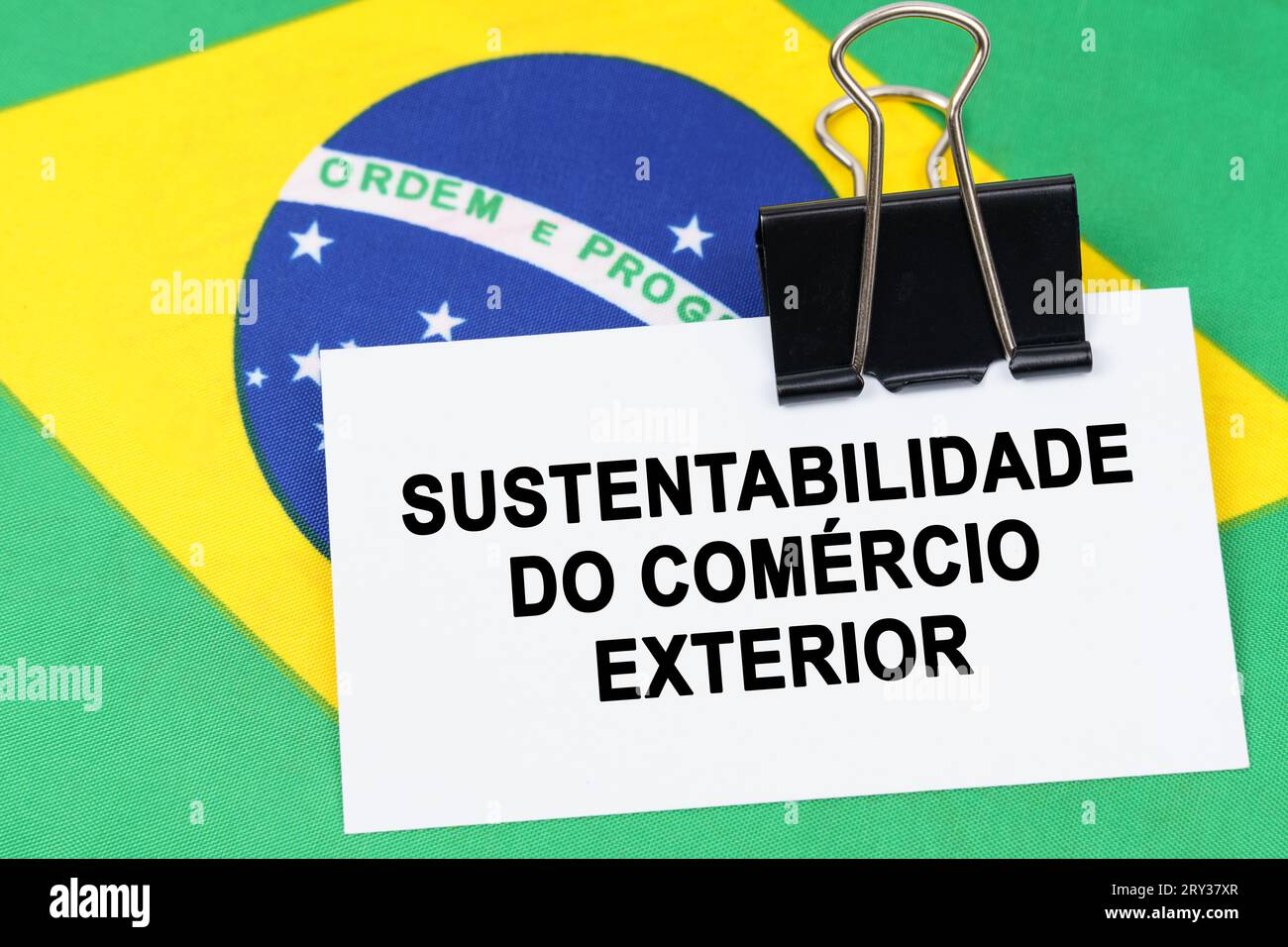 Economy and finance concept. On the flag of Brazil lies a business card with the inscription - sustainability of foreign trade. Text in Portuguese. Stock Photo