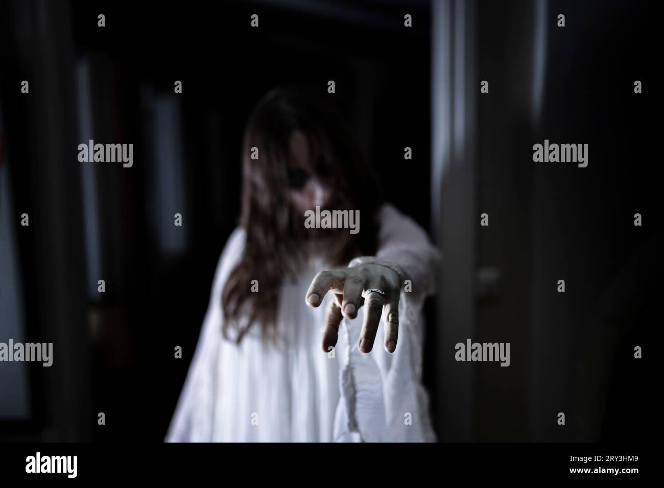 Spooky ghost reaching out at house Stock Photo