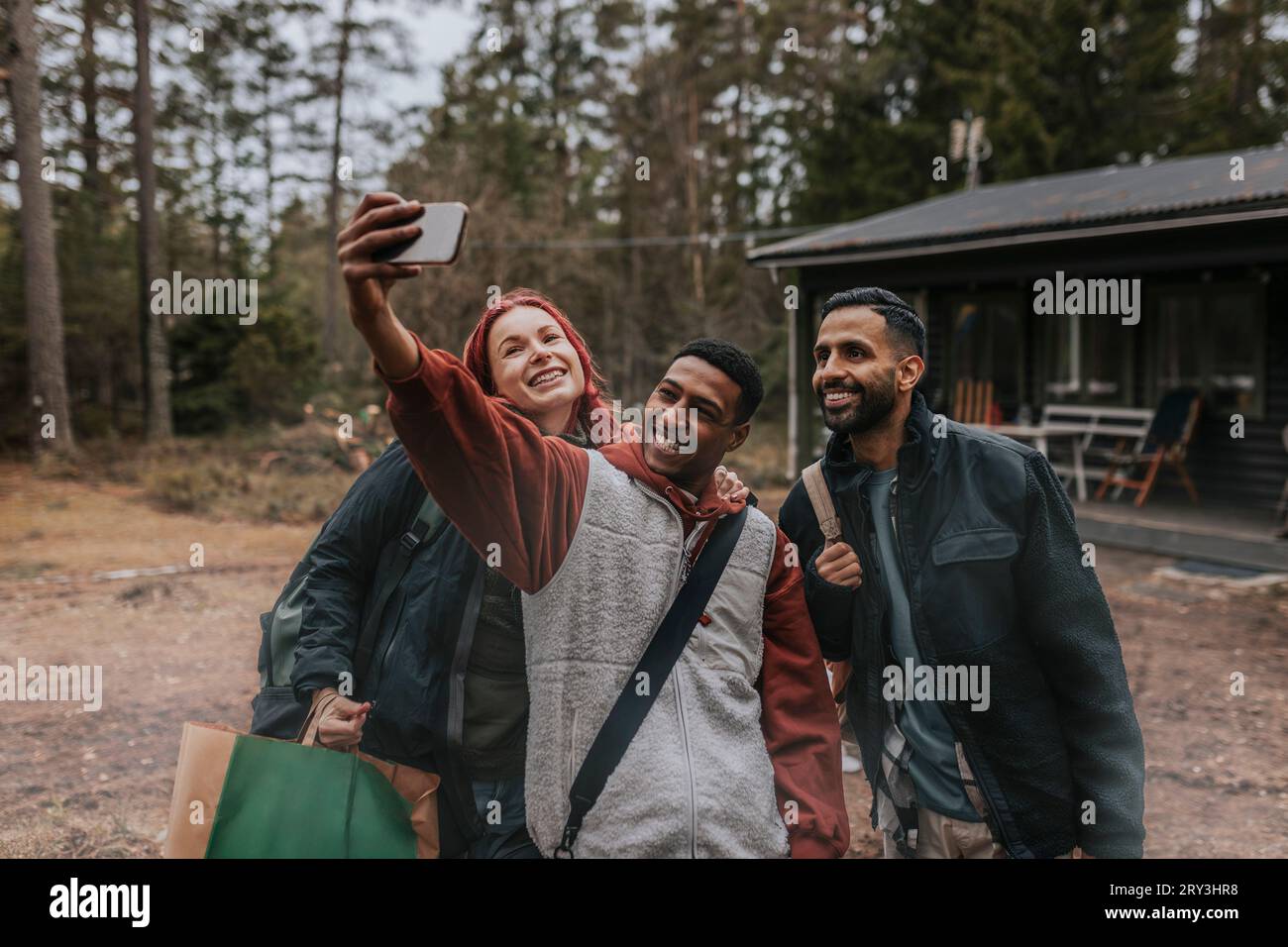 Happy friends taking selfie with mobile phone in yard Stock Photo