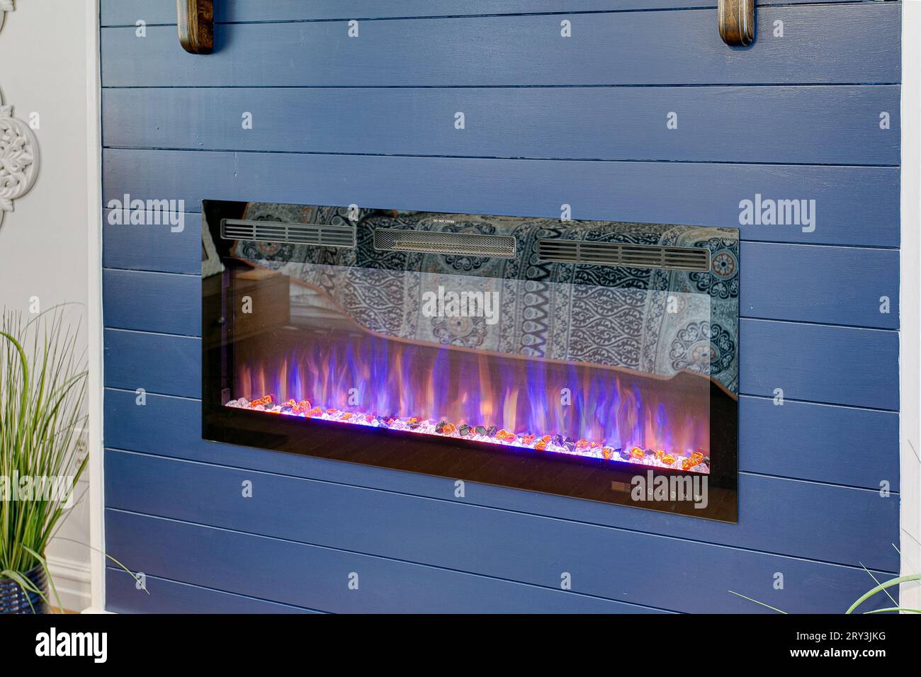 Sleek Electric Fireplace Built in Blue Accent Panel Modern Wall with Fire Burning. Copyspace ...