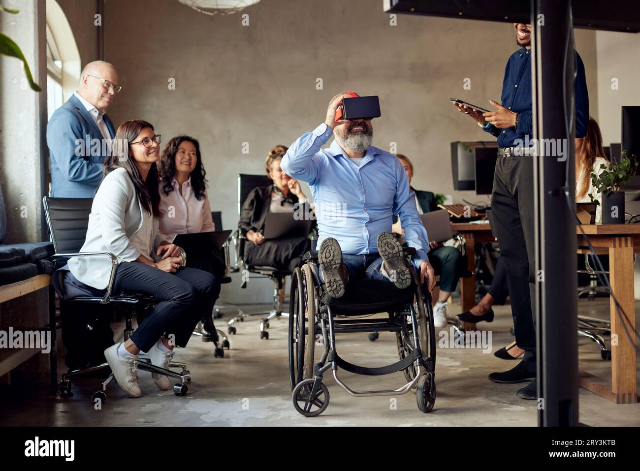 Businessman with disability wearing VR simulator amidst colleagues at creative office Stock Photo