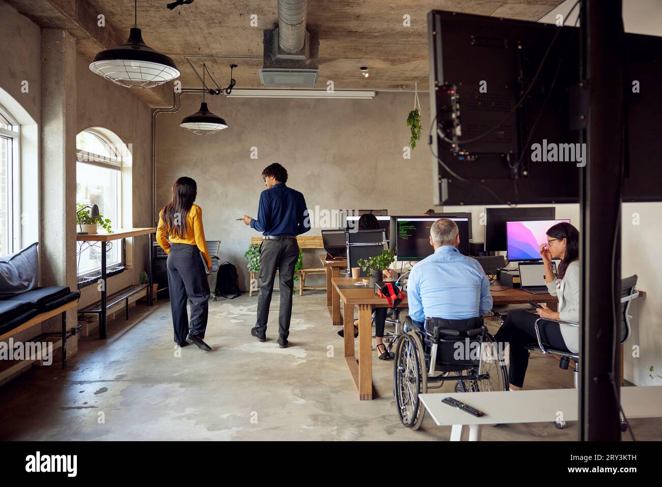 Colleagues discussing while working together at creative office Stock Photo