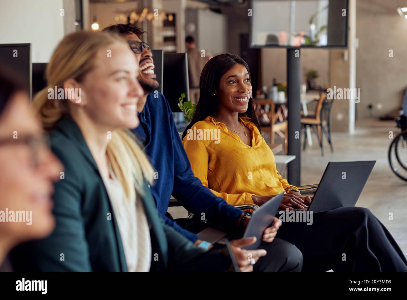 Happy multiracial business professionals sitting together at office ...