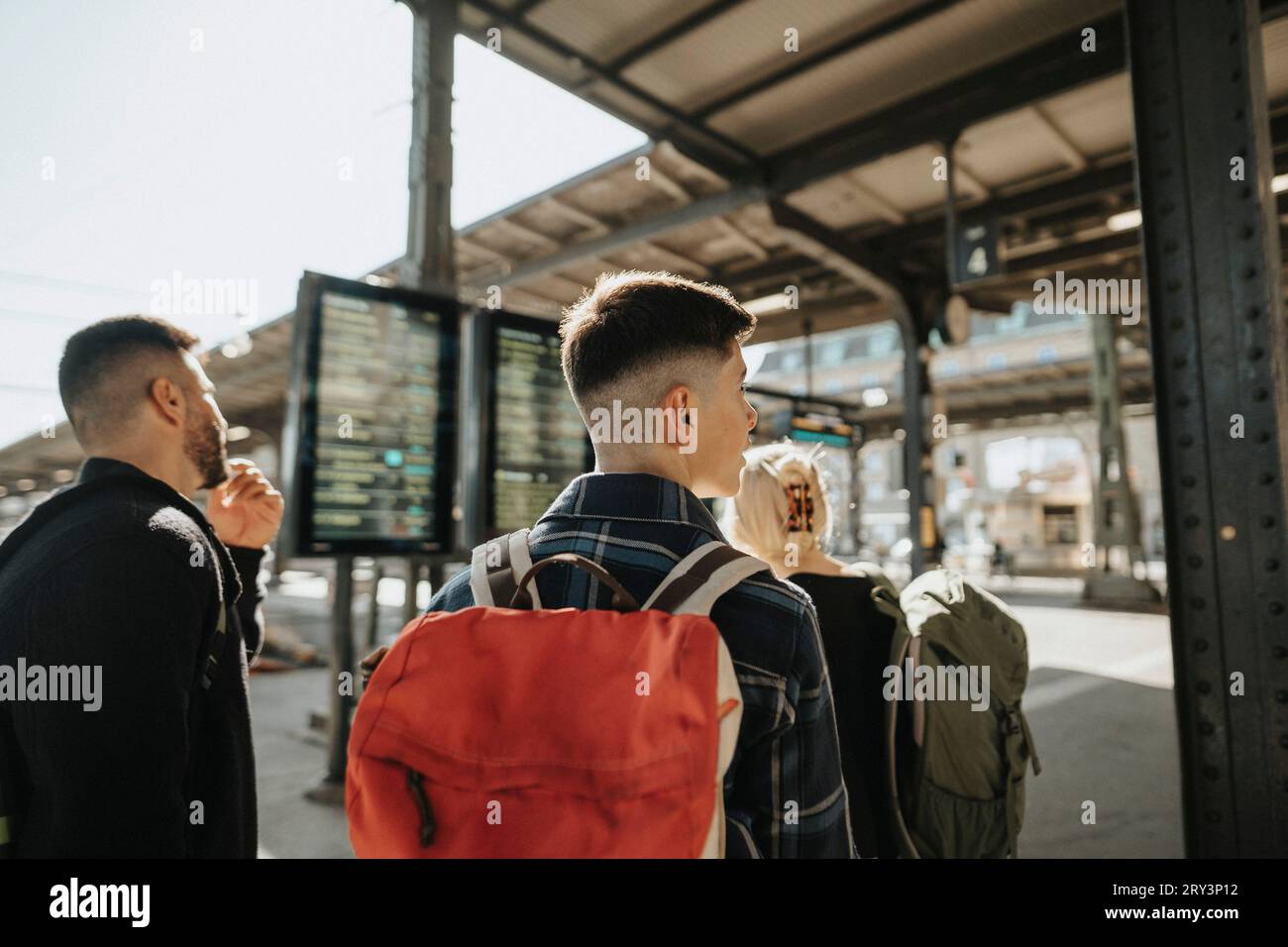 Rear view of boy with backpack at railroad station Stock Photo