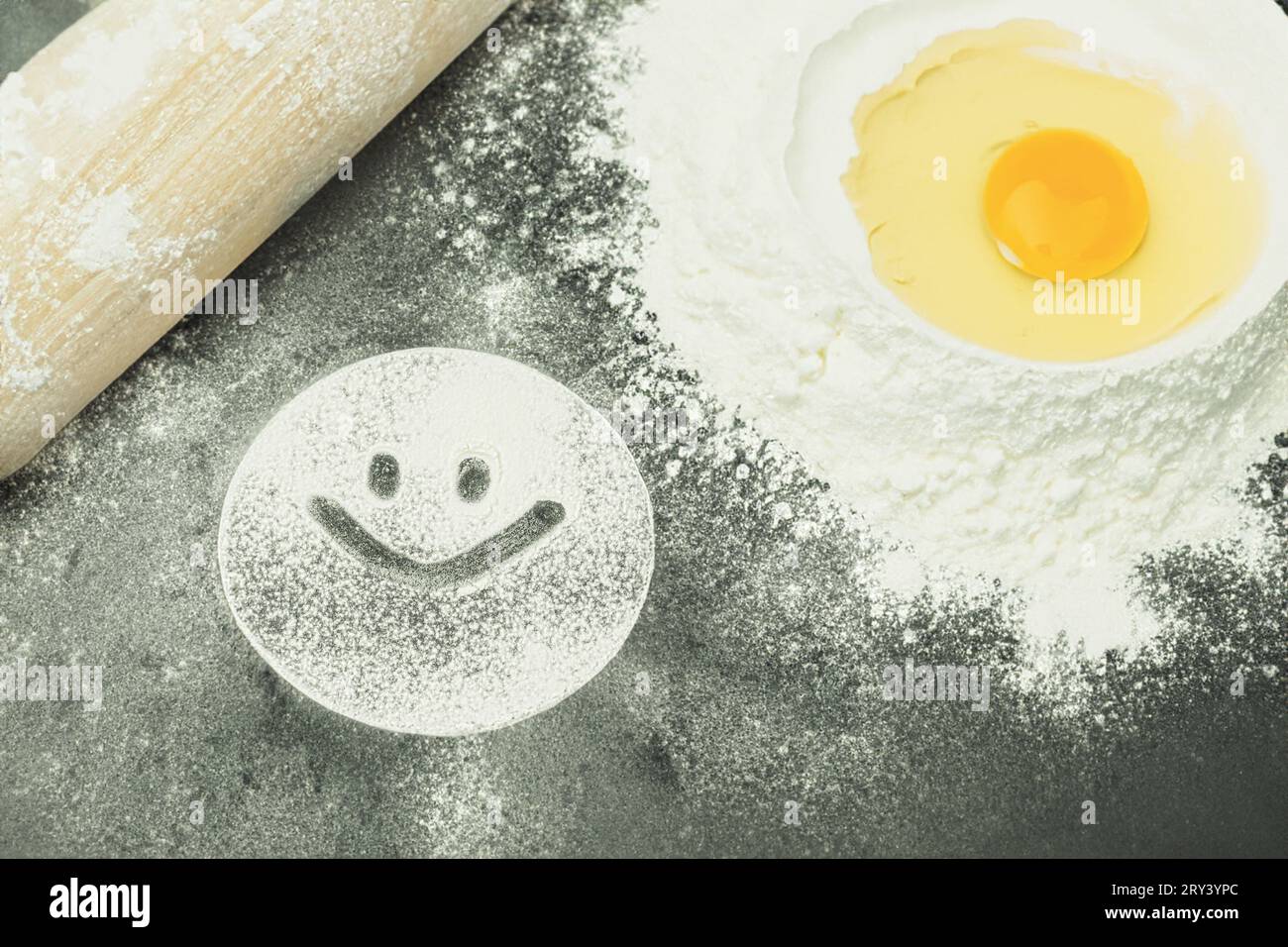 Flour is scattered on the table, smiley on the table with flour. A