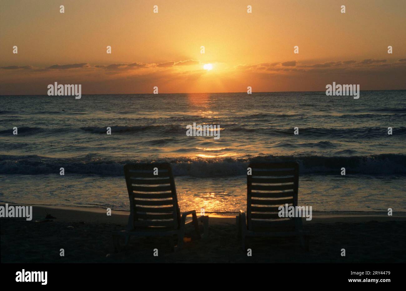 Chairs on the beach at sunset, Negril, Jamaica Stock Photo