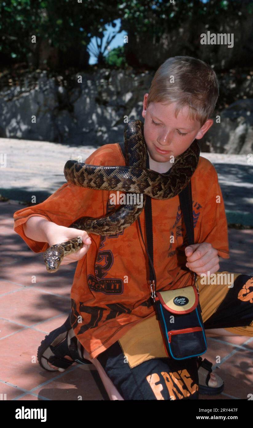 Boy with snake around his neck, Varadero, Cuba Stock Photo