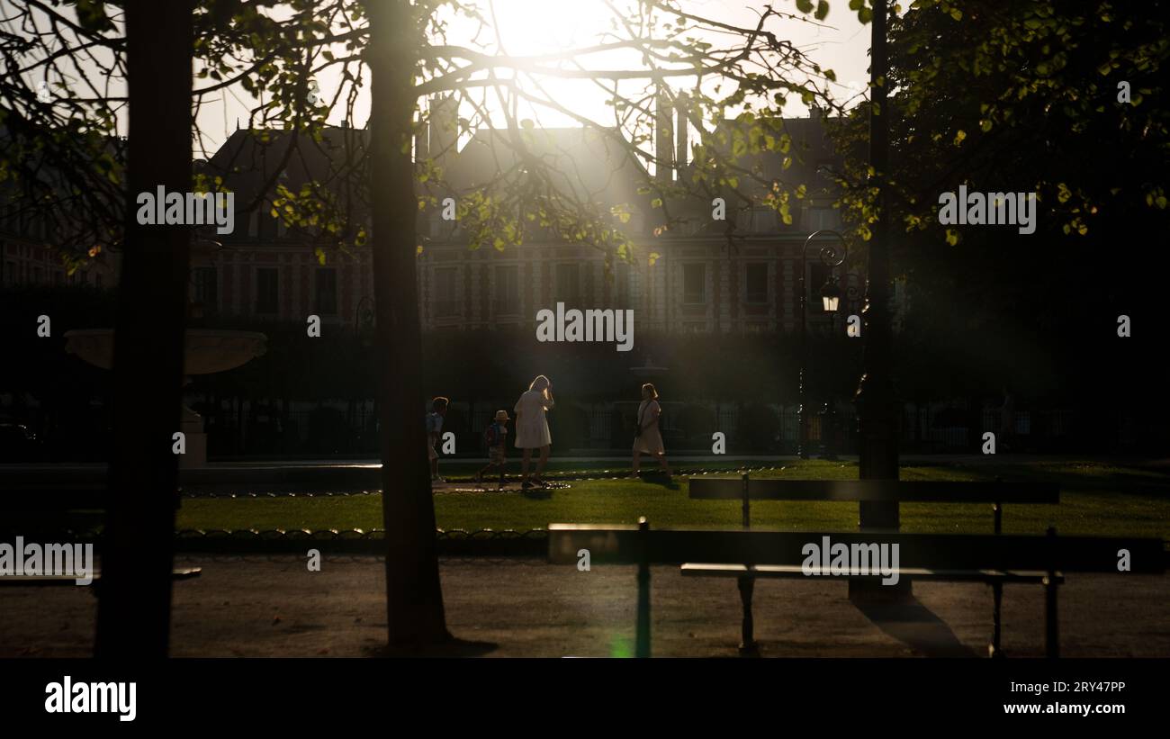 Walking to school through the park in the early morning light, le Marsias, Paris, France Stock Photo