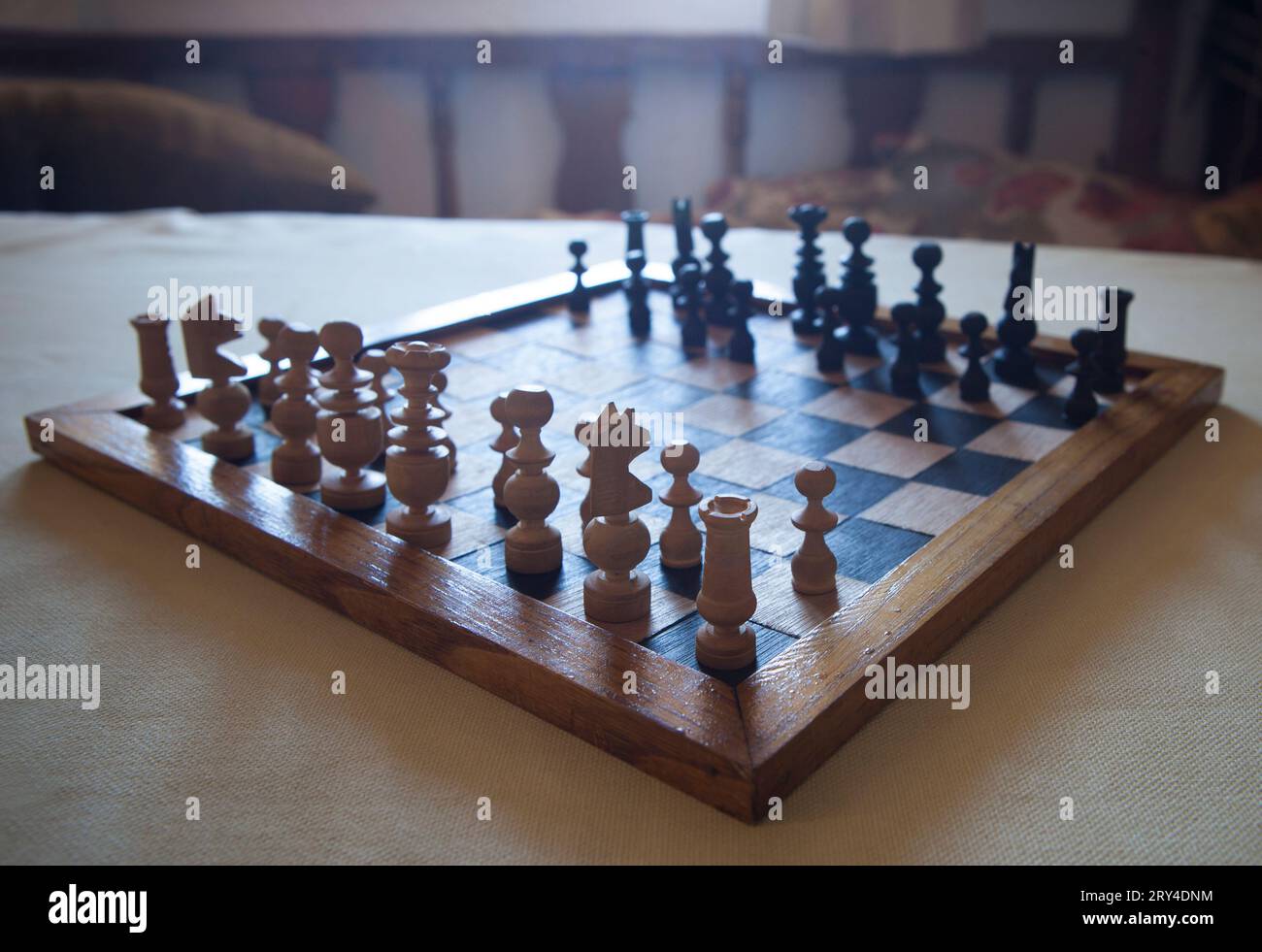 Wood turned chess board seen against the light. Cottage living room background Stock Photo