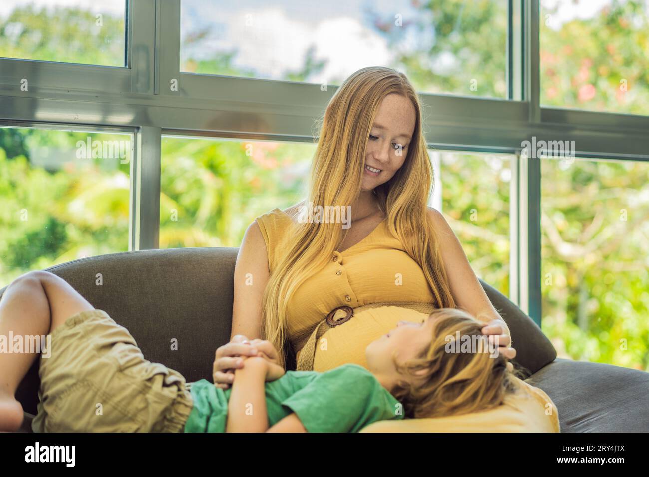 A heartwarming moment pregnant mother and her older son sit on the