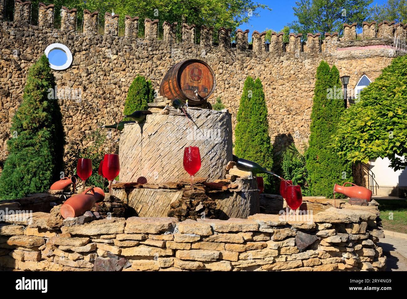 Wine bottles pourring red wine in wine glases at the wine fountain of