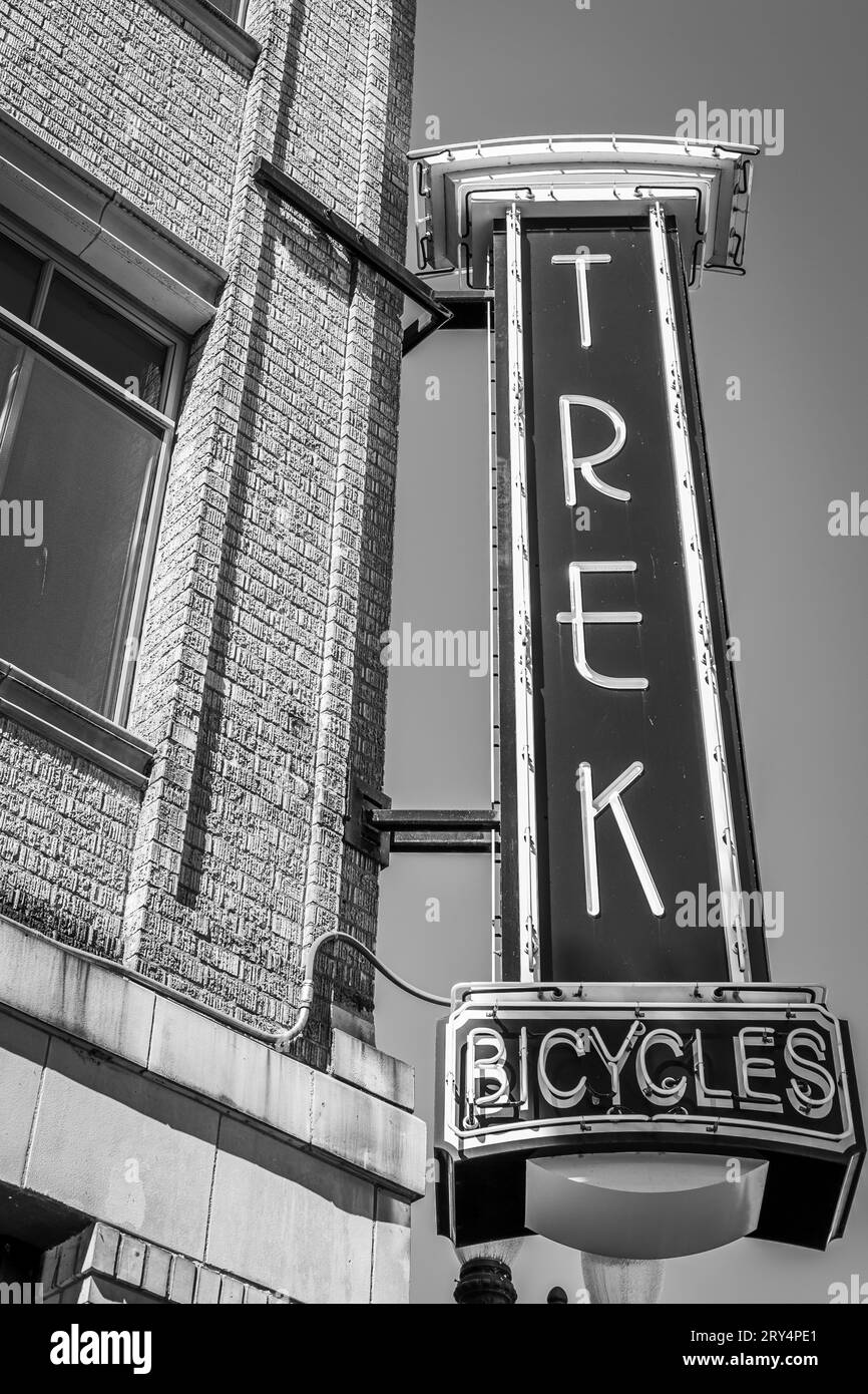 Neon Trek Bicycles sign hanging from the side of the building at the