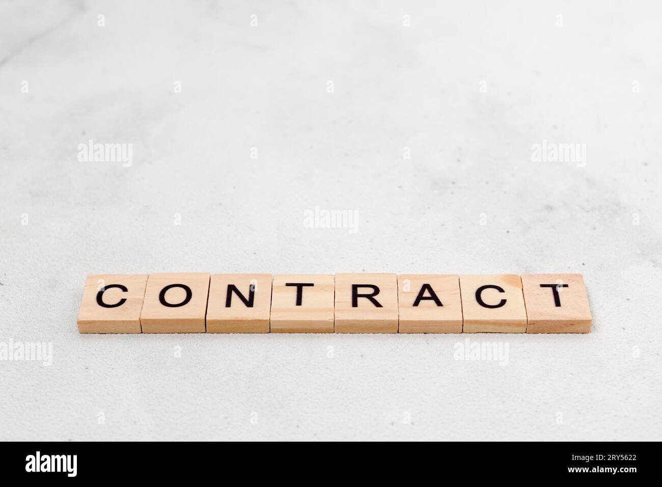 Top view of contract word on wooden cube letter block on white background. Business concept