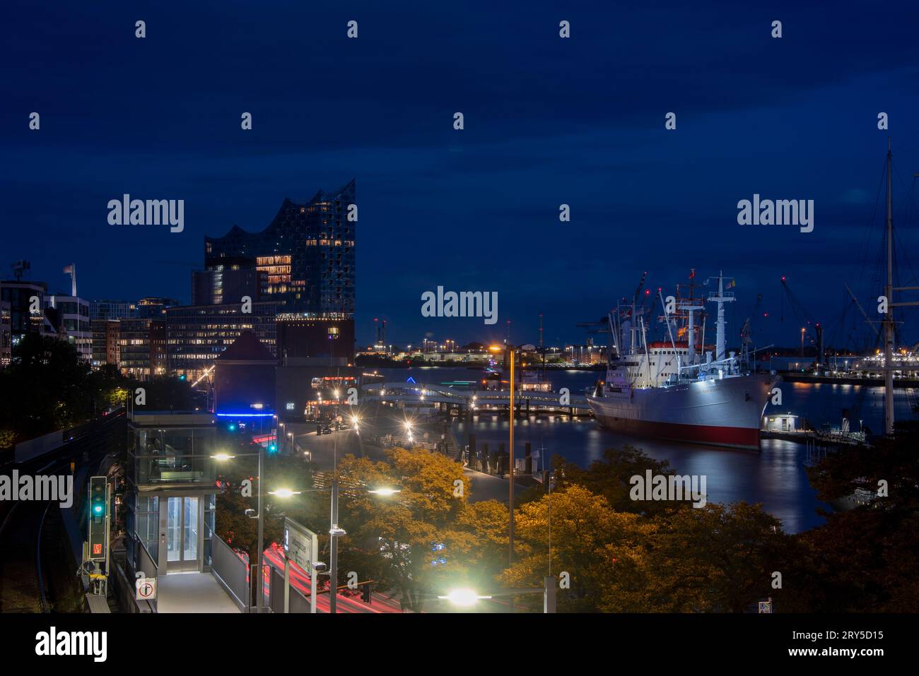 View of the Elbphilharmonie at blue hour. The museum ship Cap San Diego can be seen to the right Stock Photo