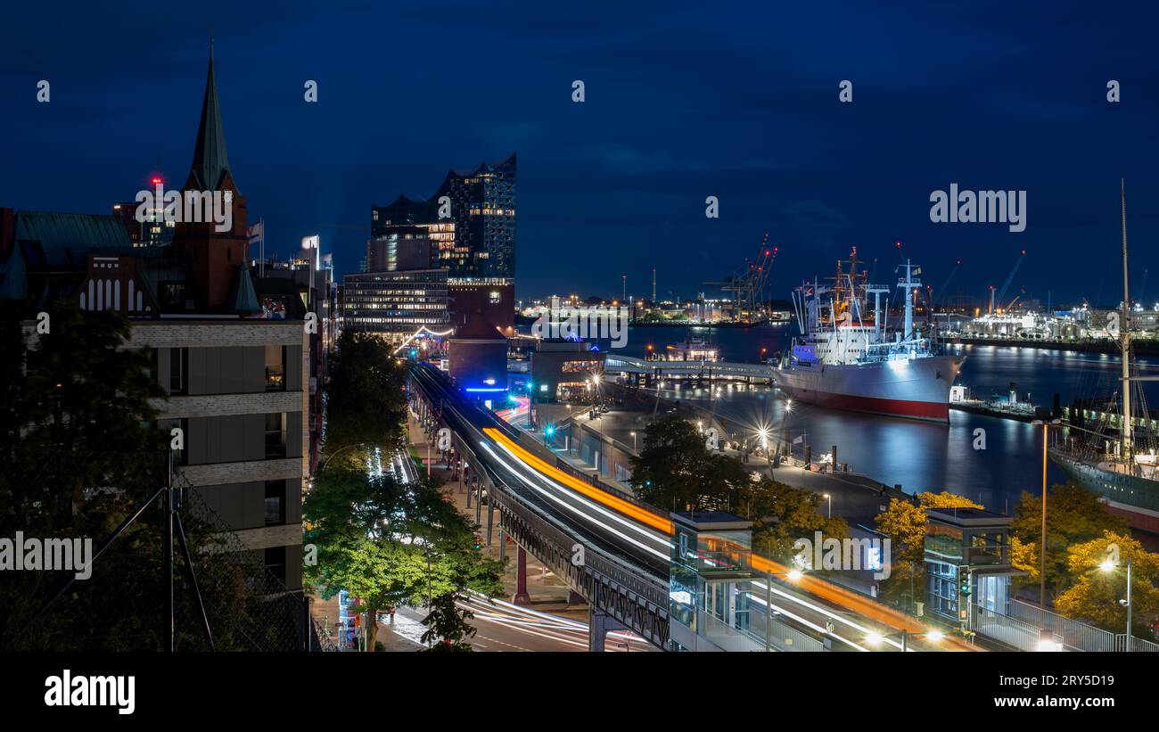 View of the Elbphilharmonie at blue hour. The museum ship Cap San Diego can be seen to the right Stock Photo