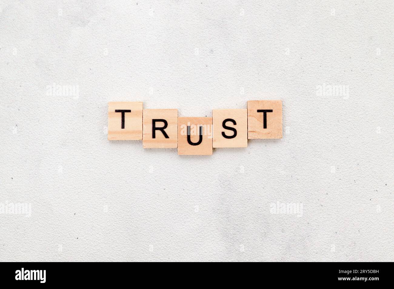 Top view of Trust word on wooden cube letter block on white background. Business concept Stock Photo