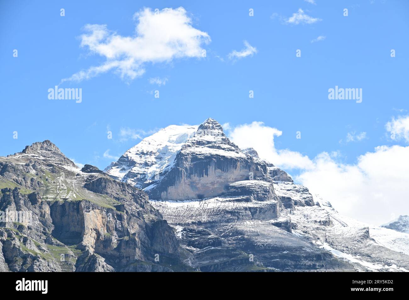 The snow mountain rises high under the blue sky Stock Photo