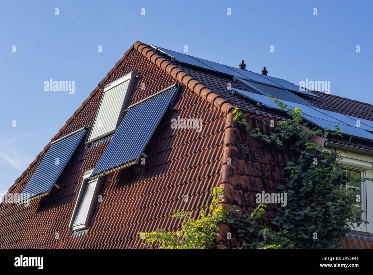 photovoltaics and tube collectors on a hipped roof Stock Photo - Alamy
