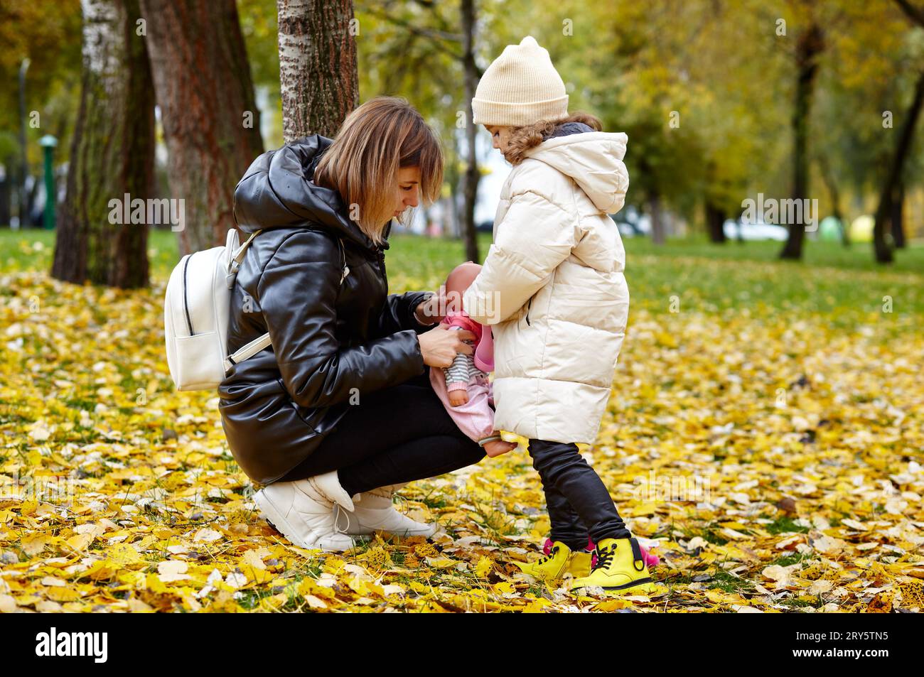 Hello october. Mother and daughter are walking in the autumn city park ...