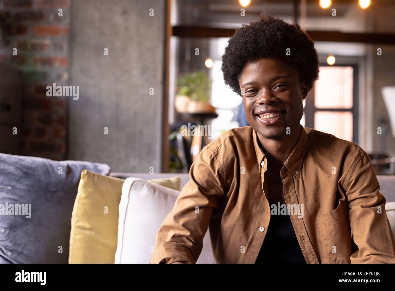 Man sitting couch smiling hi-res stock photography and images - Alamy