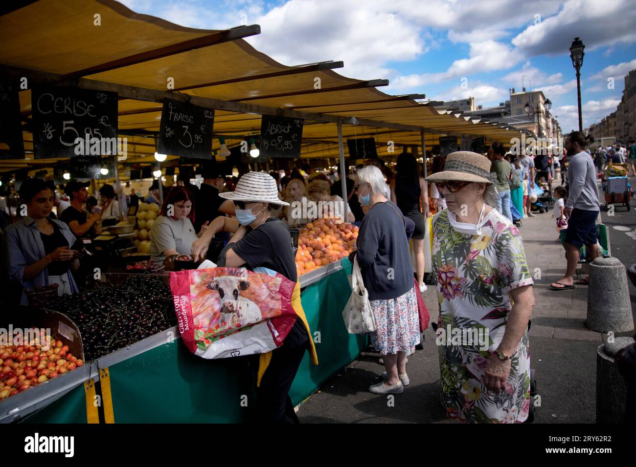 FILE - People shop at a market in Versailles, outside Paris, France, on  July 3, 2022. Inflation that has been plaguing Europeans made a marked  decline in September, strengthening hopes that consumers
