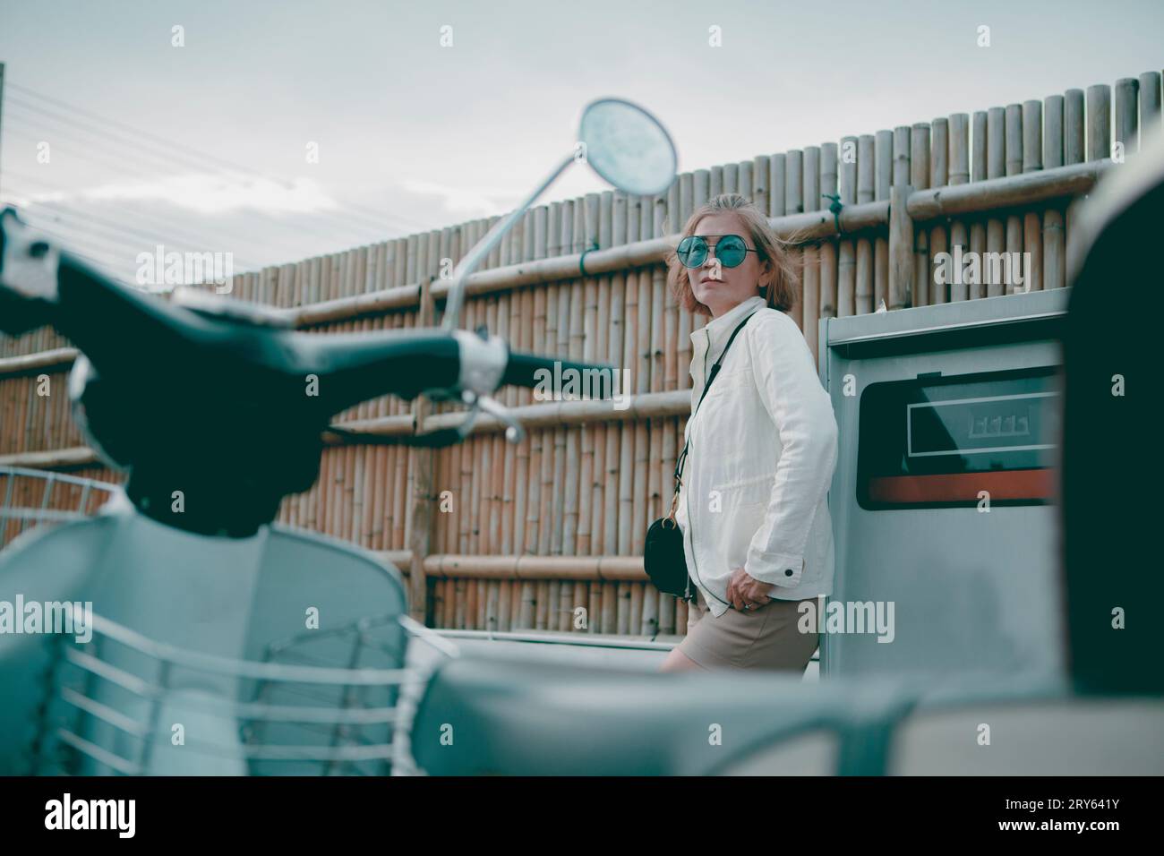 asian woman standing in gas station with female motorcycle forground Stock Photo