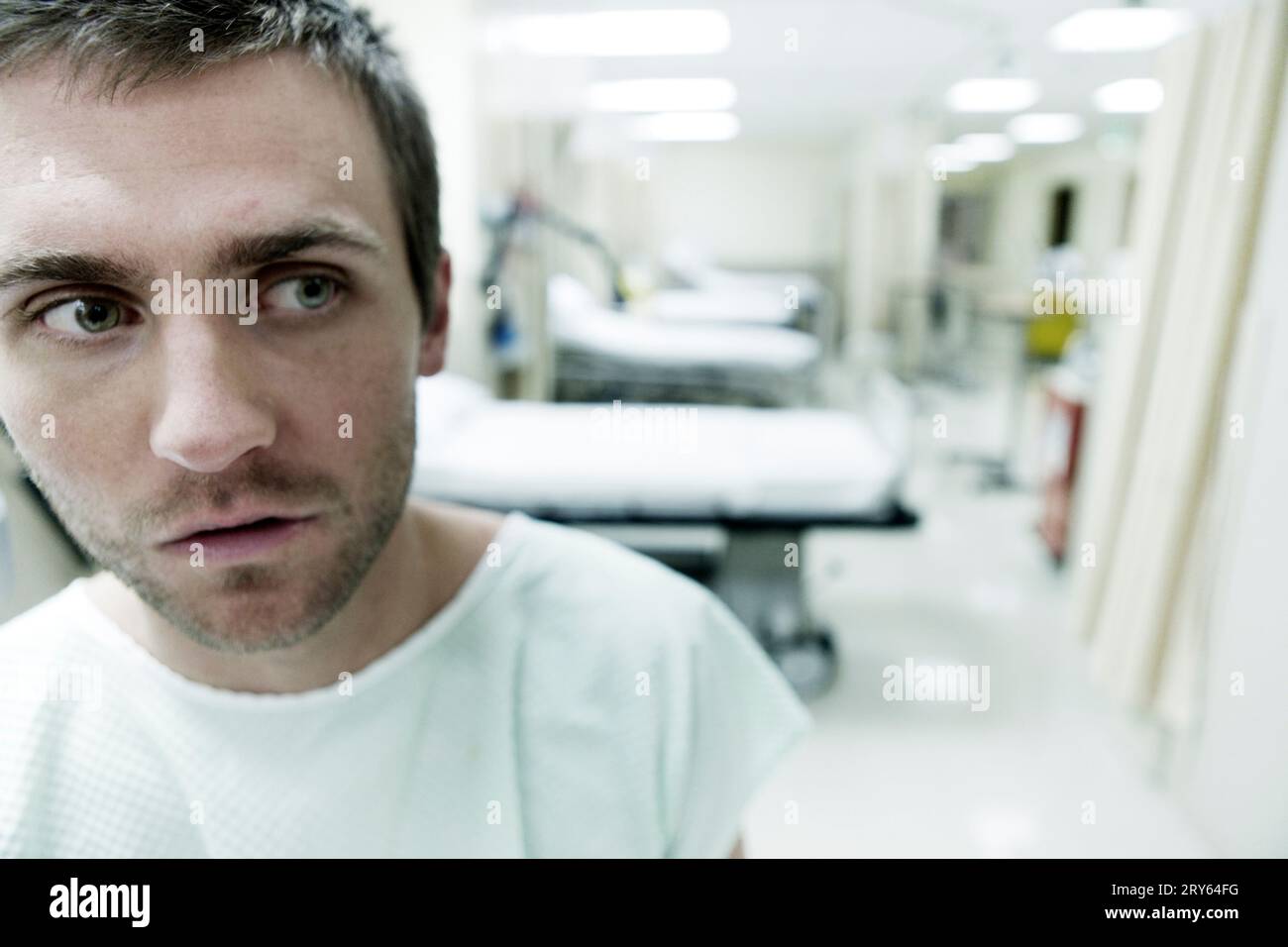 A portrait of a young man sitting in a hospital room. Stock Photo