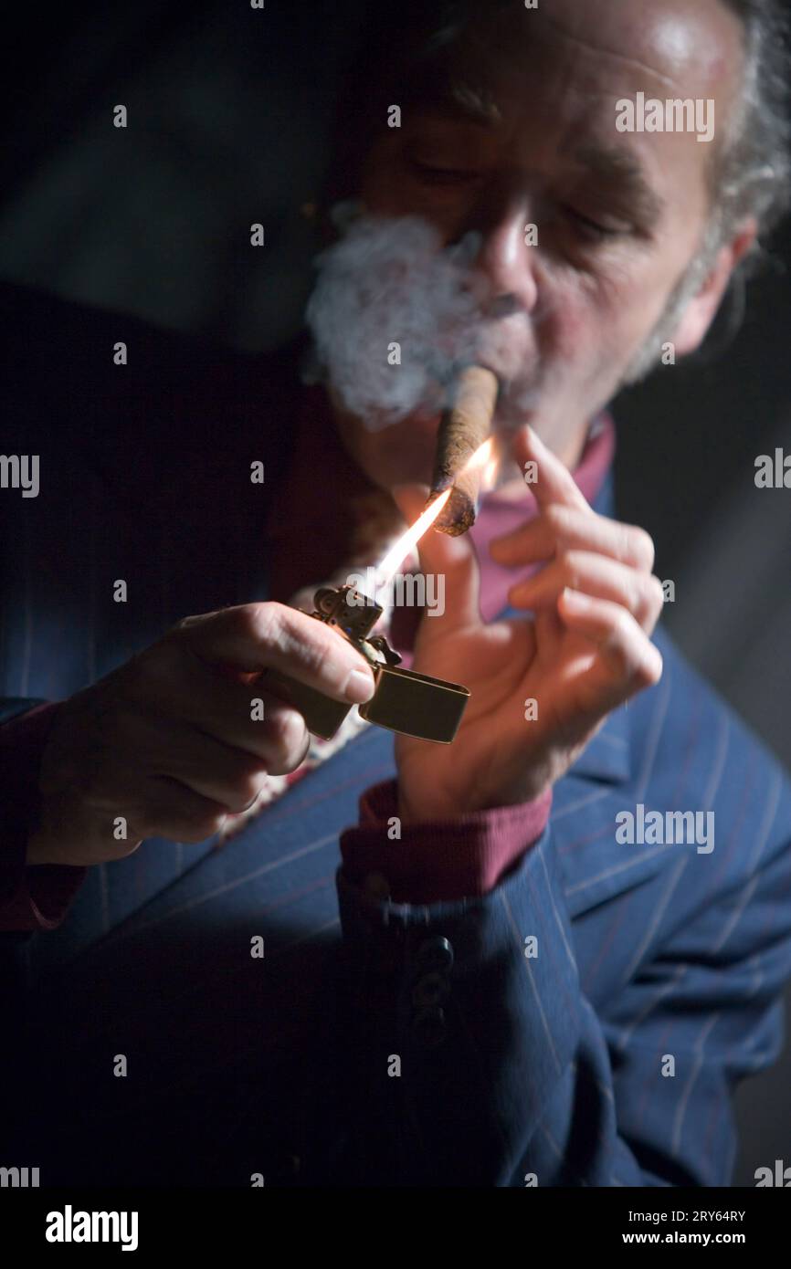 Front view of a man lighting a cigar. Stock Photo