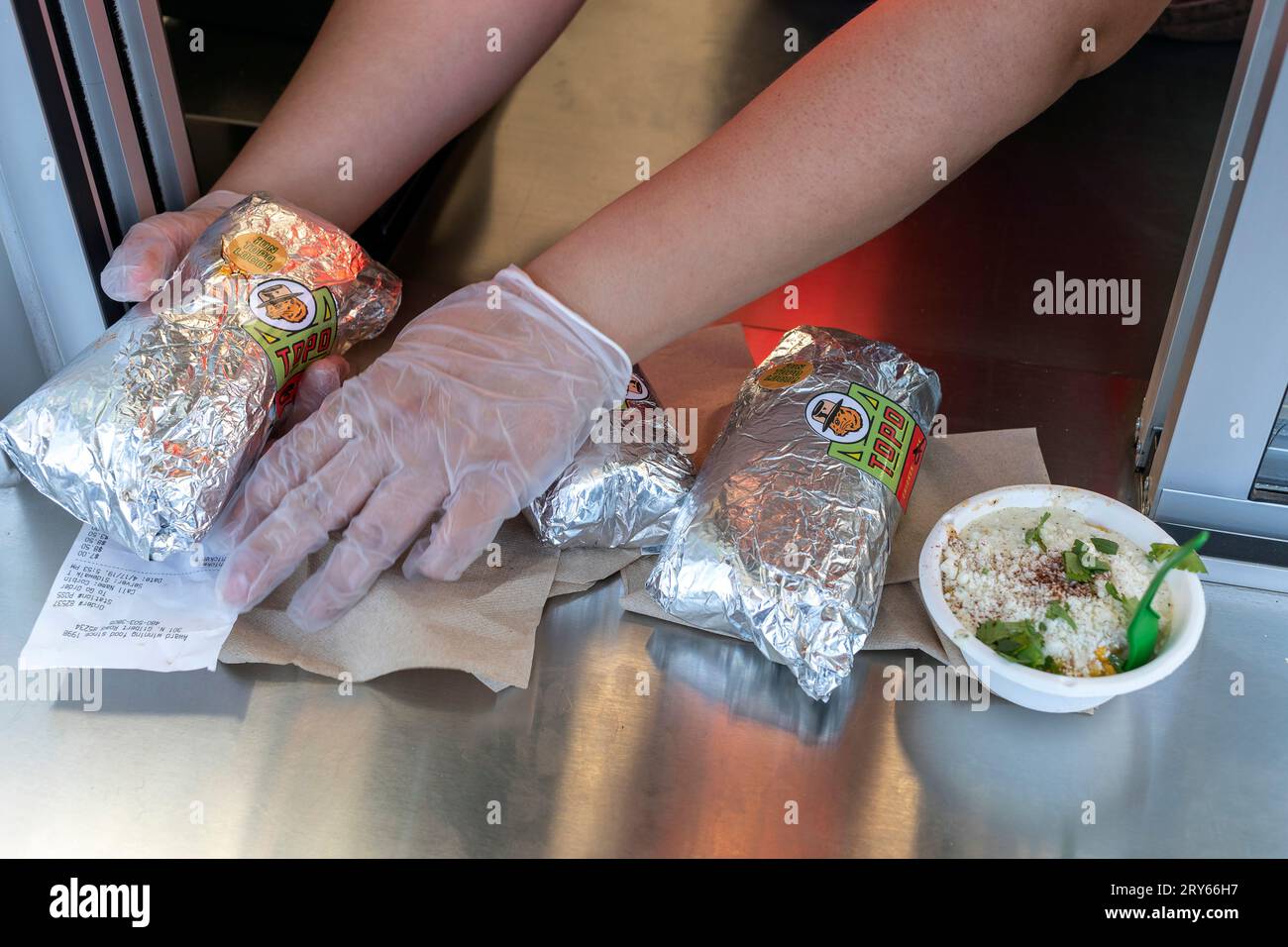 Hands putting food out on stainless counter Stock Photo