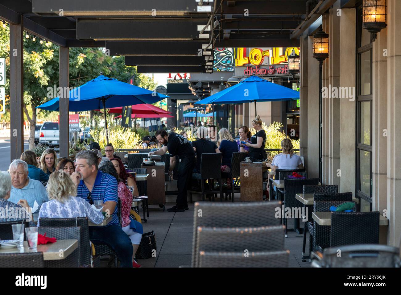 Restaurant patio on busy street with diners Stock Photo