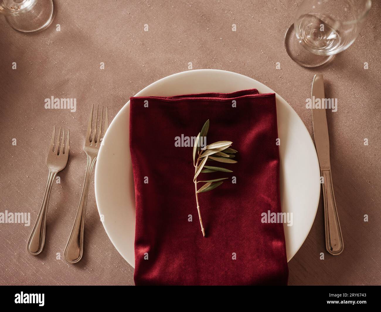 Elegant holiday table setting with a white plate, red napkin, an Stock Photo