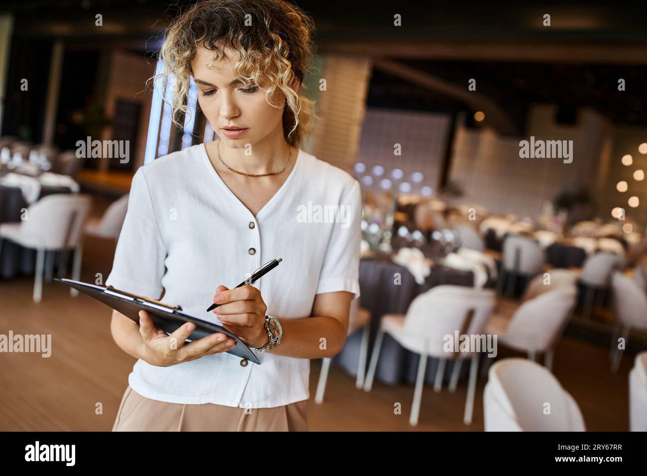 concentrated event organizer writing checklist on clipboard near