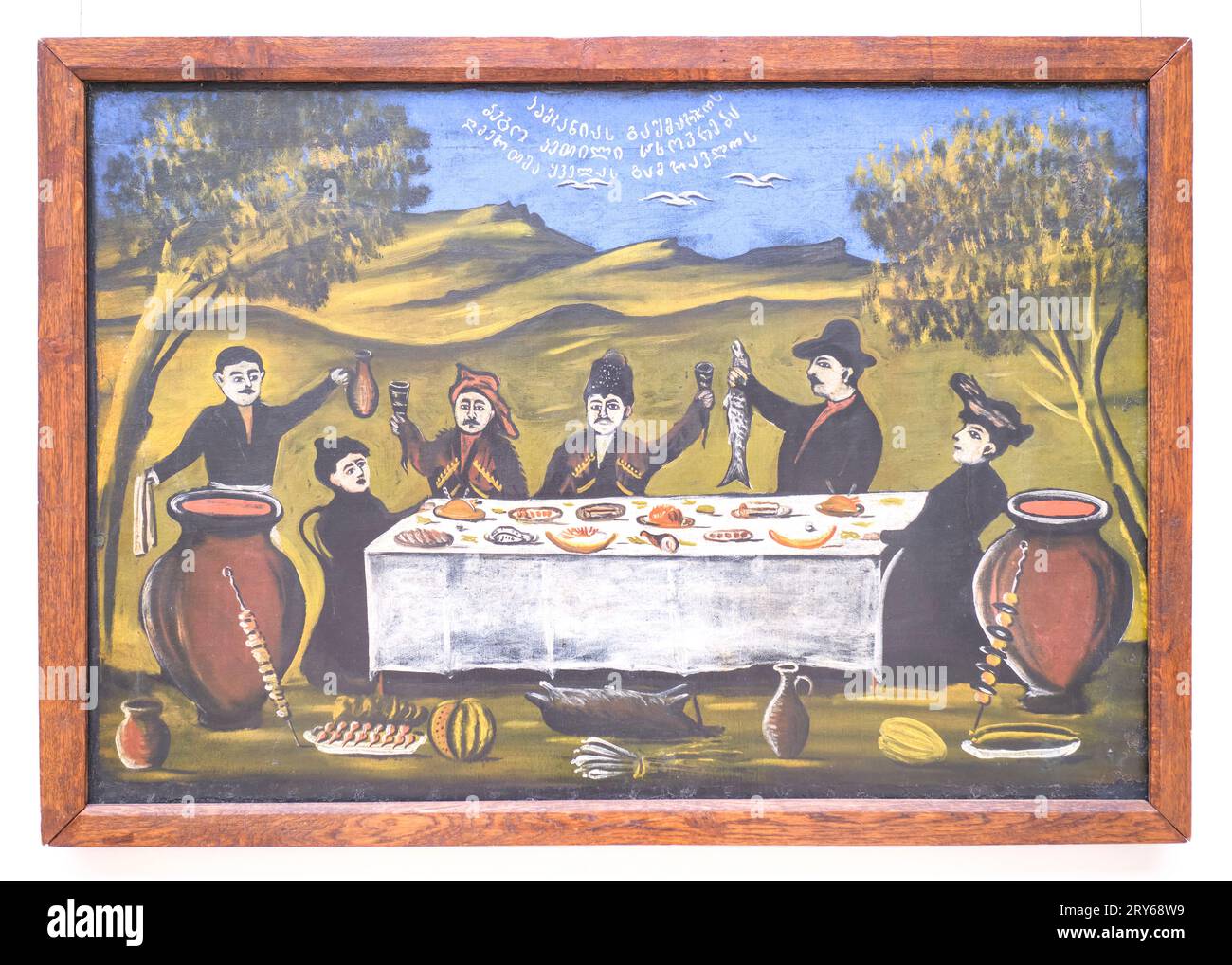 A classic, iconic painting by the artist, Niko Pirosmanashvili, of a rural, outdoor picnic celebration with fish, boar, kebab, melon and drink. In Tbi Stock Photo