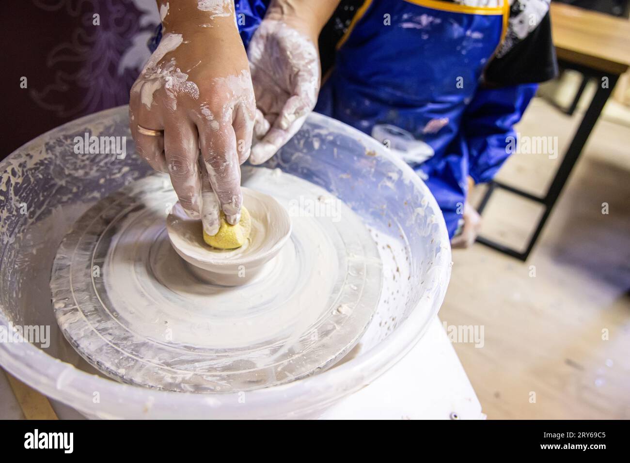 The teacher teaches the children to sculpt from clay on a potter's