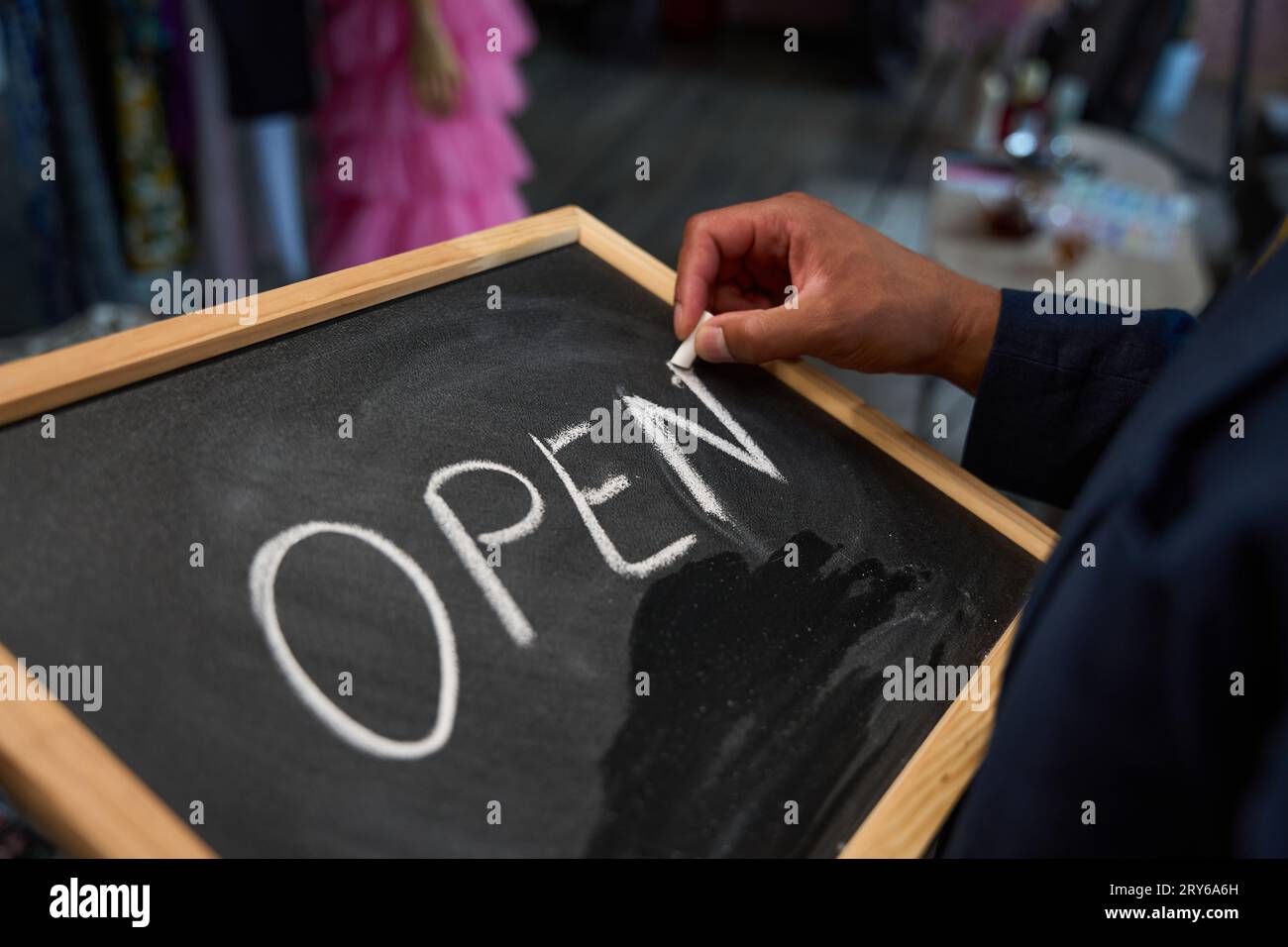 Tailor preparing chalkboard welcome sign for attracting clients to atelier Stock Photo