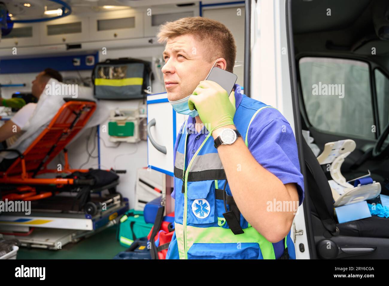 Paramedic communicates on a mobile phone near an ambulance Stock Photo