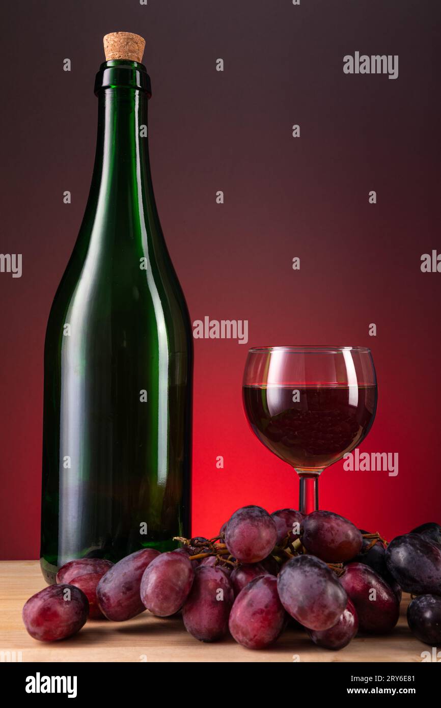 red wine still life with a bottle, class and grapes eith copy space ...