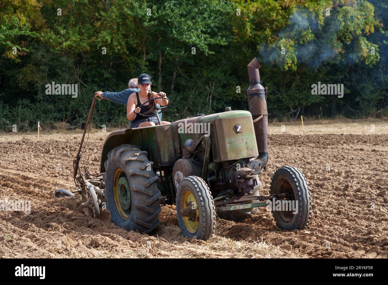 Competitors on vintage farm machinery taking place in a ploughing competition. Stock Photo