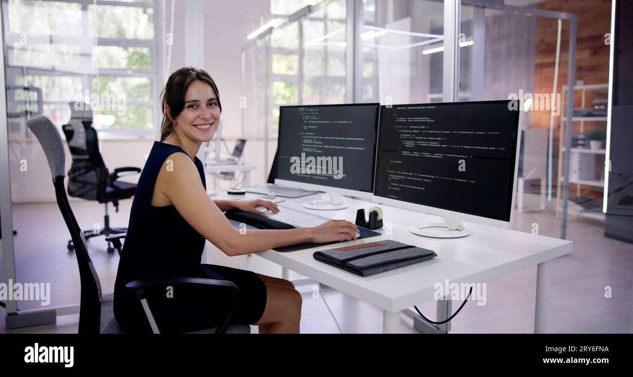 Programmer Woman Coding On Multiple Computer Screens Stock Photo - Alamy