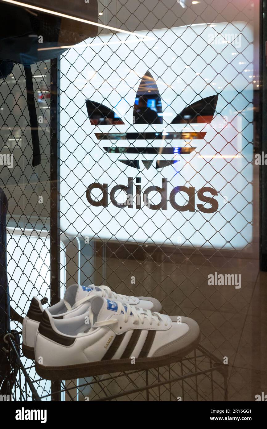 Adidas brand advertising sign and sneakers in the interior of a shoe store. Adidas neon store sign in shop window. Minsk, Belarus, September 18, 2023 Stock Photo