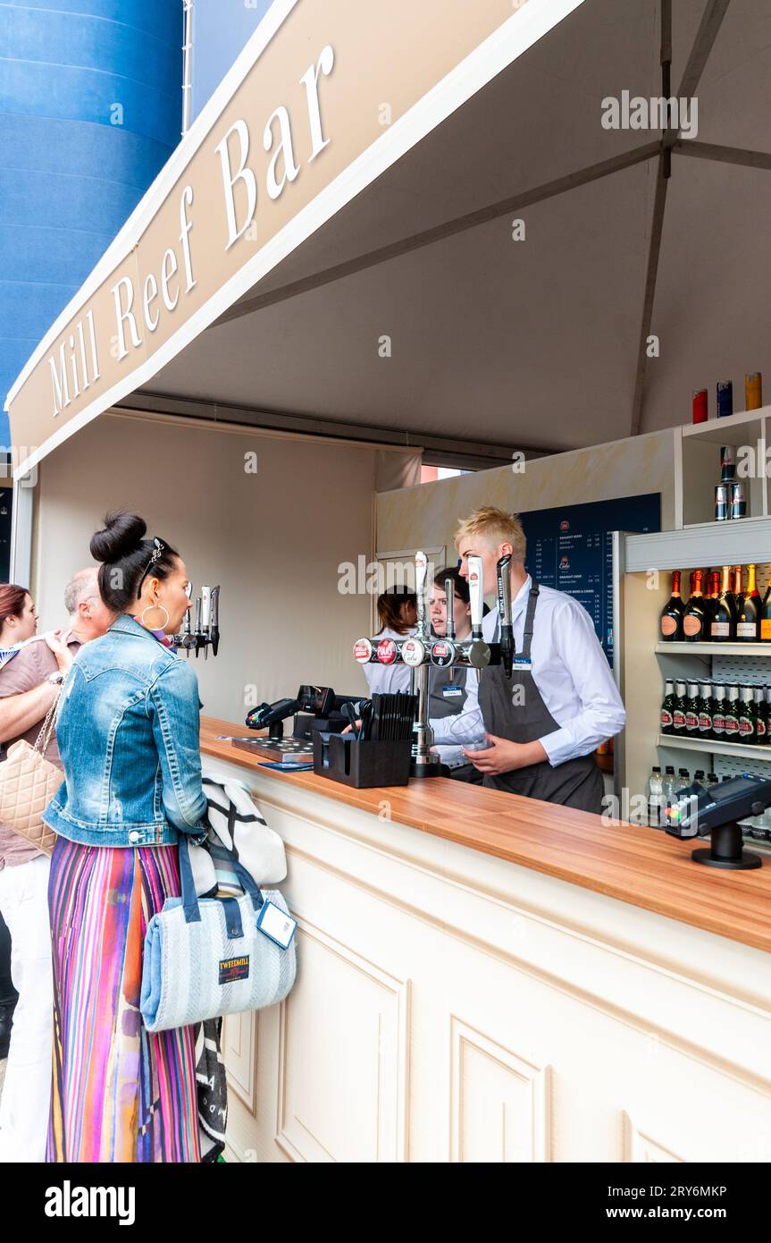 Mill Reef Bar at Royal Ascot racecourse, Berkshire, UK. Bar staff serving customers. Draught and bottled alcohol available Stock Photo