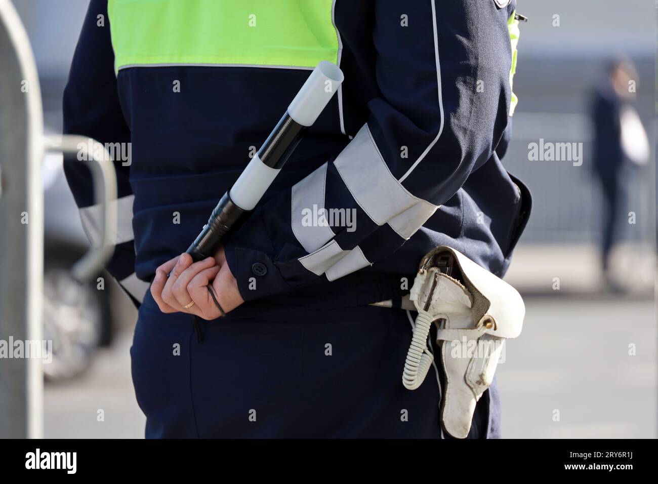 Police officer standing with traffic rod. Policeman patrol the city