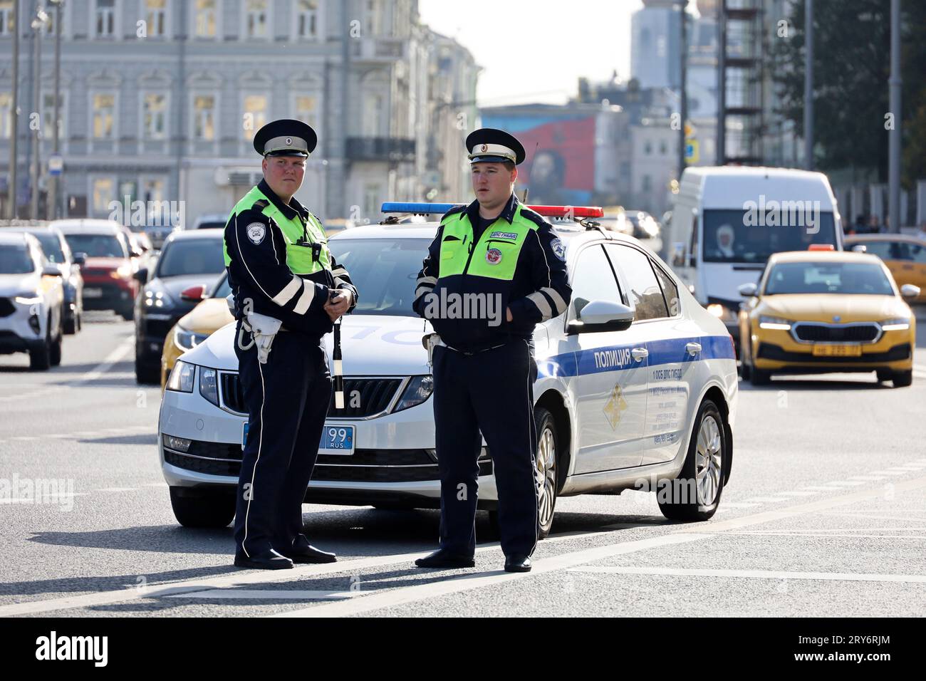 Two traffic police officers standing near the car on the road. Policemen on the street, traffic cop Stock Photo