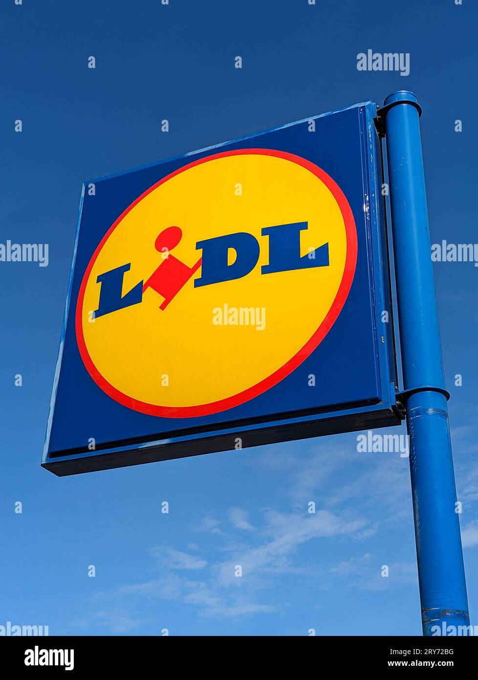 Sign and logo of a Lidl supermarket. Blue sky in the background. Lidl is a German retail group known for its low prices Stock Photo