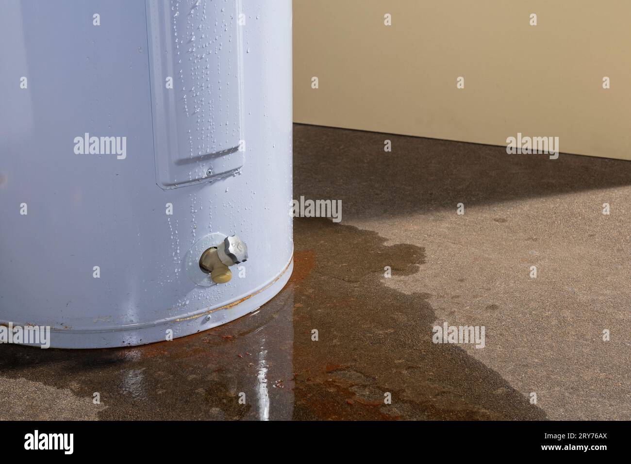 Water leaking from a residential electric water heater sitting on a
