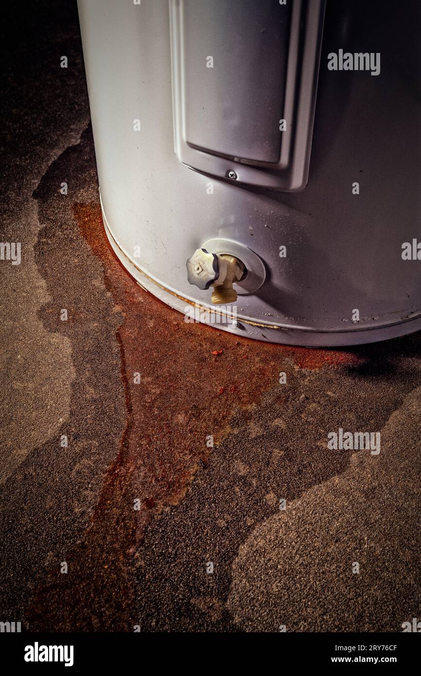 Water leaking from a residential electric water heater sitting on a