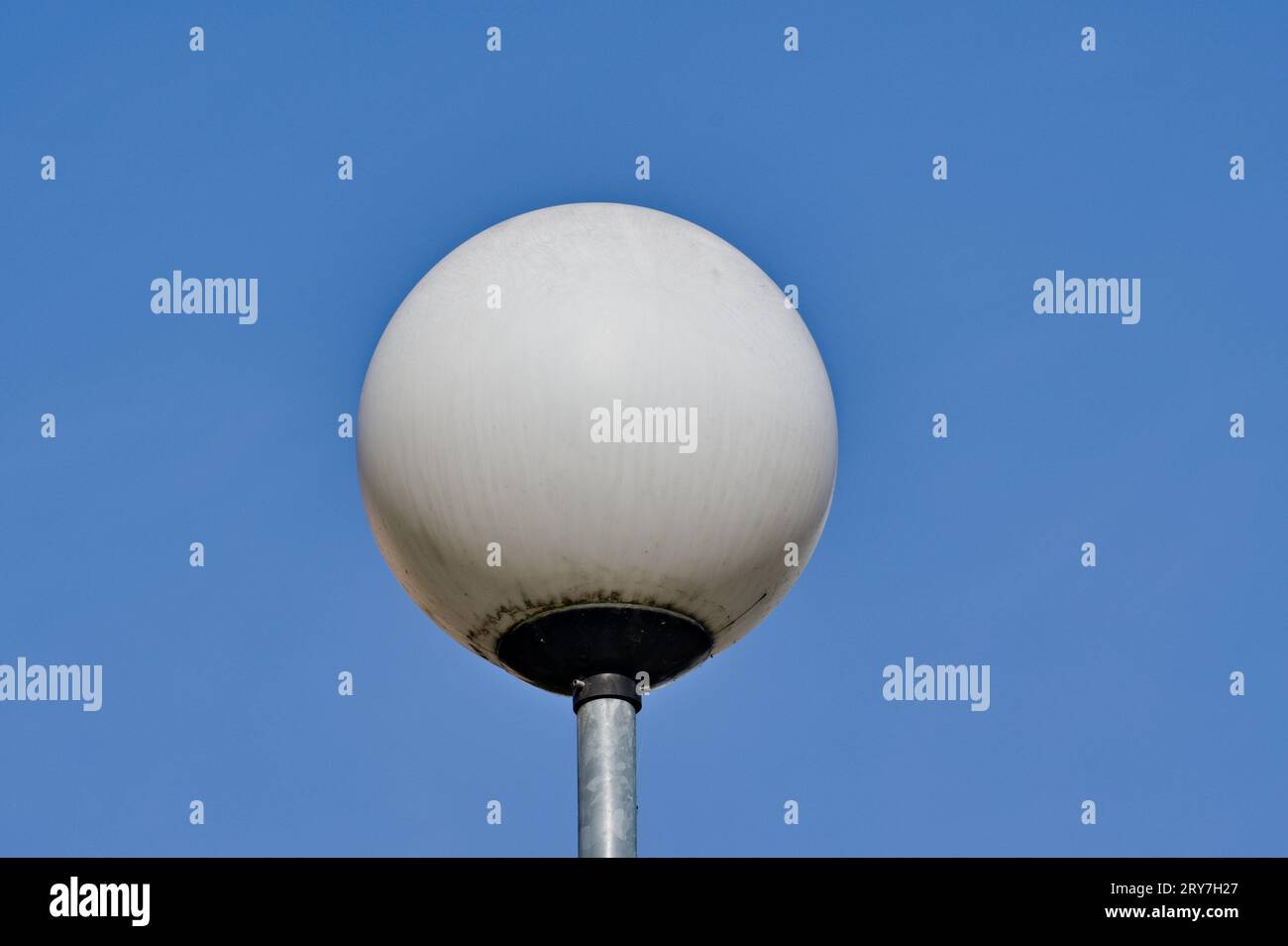 Round white streetlamp and blue sky background. Stock Photo