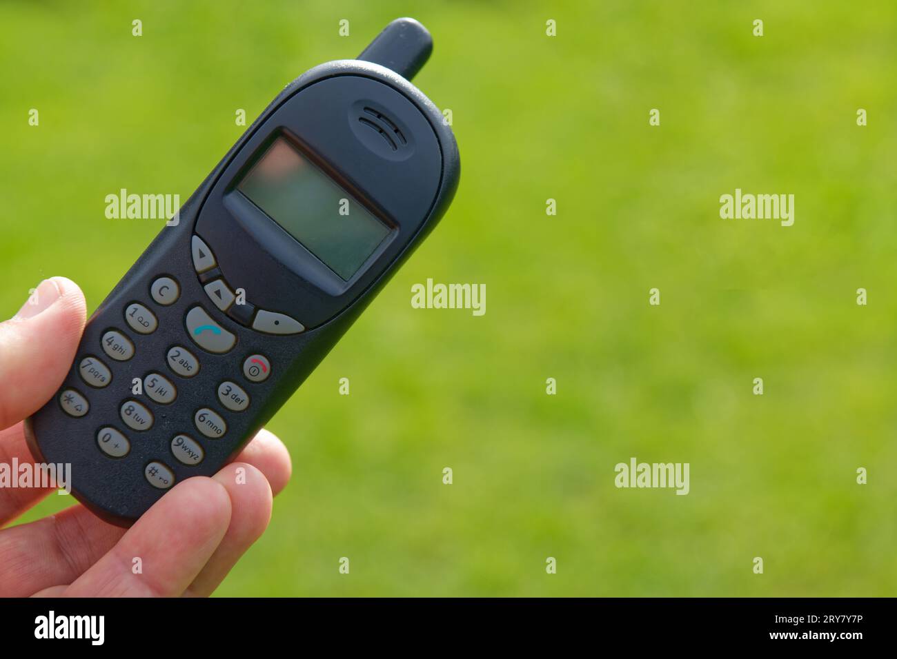 An old push-button cell phone in a hand Stock Photo