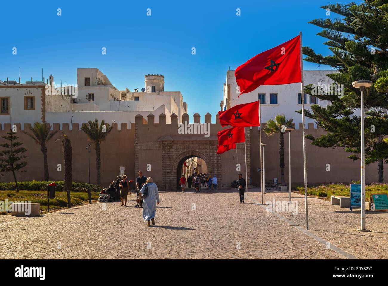 Essaouira, Morocco - August 3, 2023: The access road to one of the gates to the historic center of the town, among the waving Moroccan flags. Citylife Stock Photo
